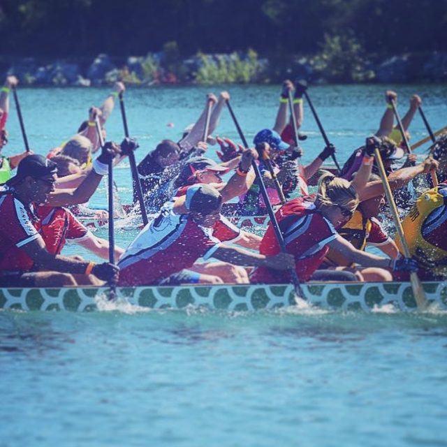 A dragon boat crew digging in mid-race