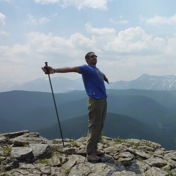 Arms out on a summit ridge with a trekking pole